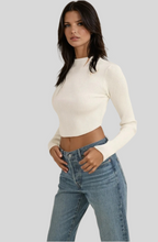 Load image into Gallery viewer, Women’s cropped ribbed knit sweater in ivory white, long sleeves, mock neck, styled with high-waist blue jeans
